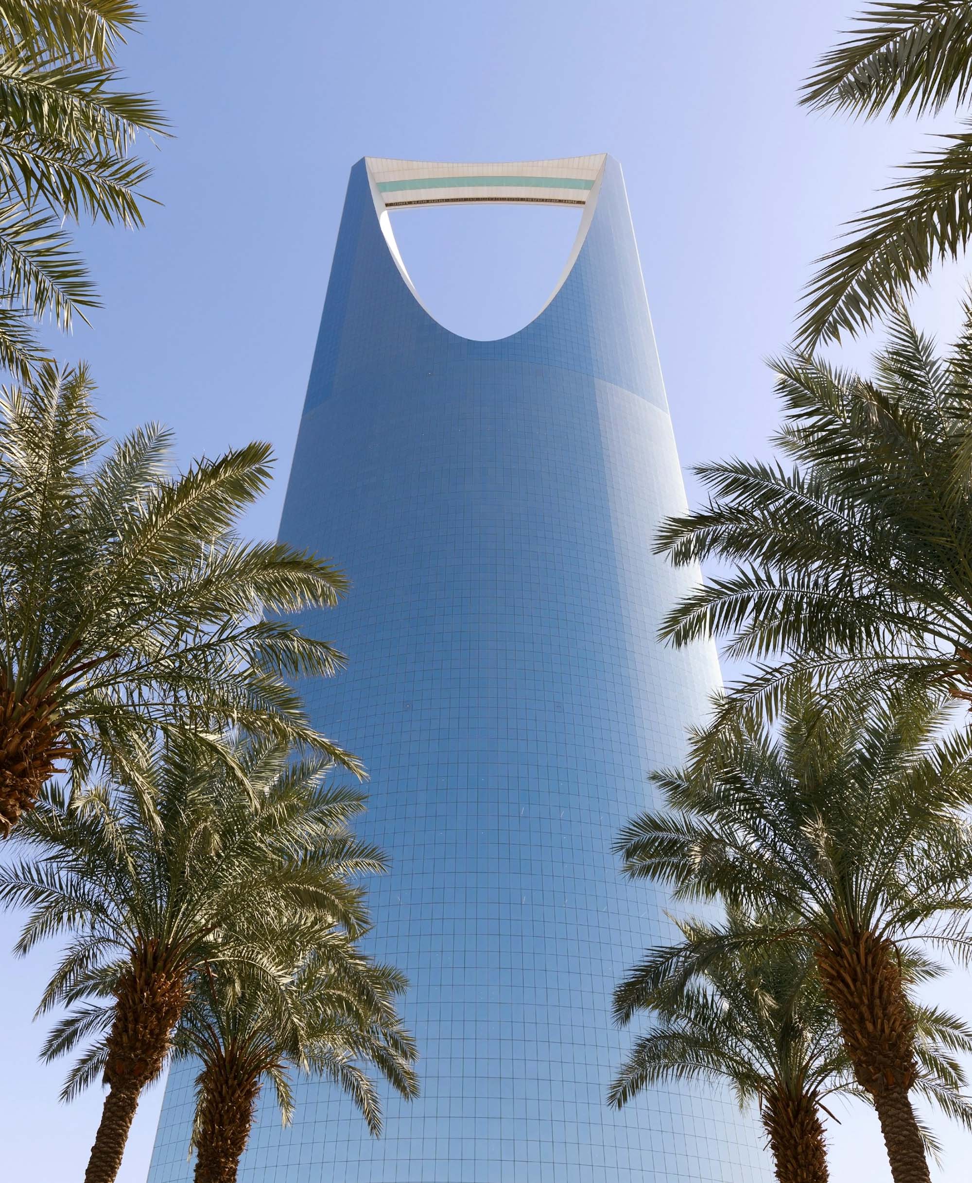Riyadh skyline at sunset — Kingdom Tower against an amber sky.